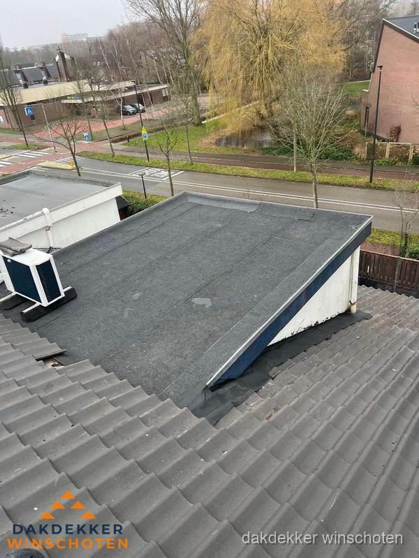 Plat dak met bitumen dakbedekking naast schuin pannendak in Winschoten Plat dak met bitumen dakbedekking naast schuin pannendak in Winschoten
